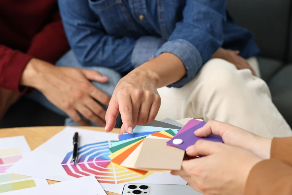 Dos colaboradores seleccionan colores para personalizar productos que fortalecen el reconocimiento de marca con una identidad visual.